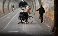 Schmuckbild; Ein Passant mit Bueostuhl im Fussgaenger - und Radtunnel am Haagtor